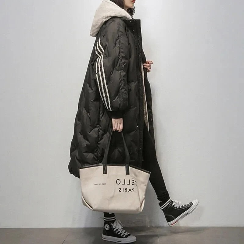 Michelle, doudoune longue noire pour femme avec capuche et bandes décoratives sur les manches, manteau d’hiver chaud et élégant, parfait pour un look urbain confortable.