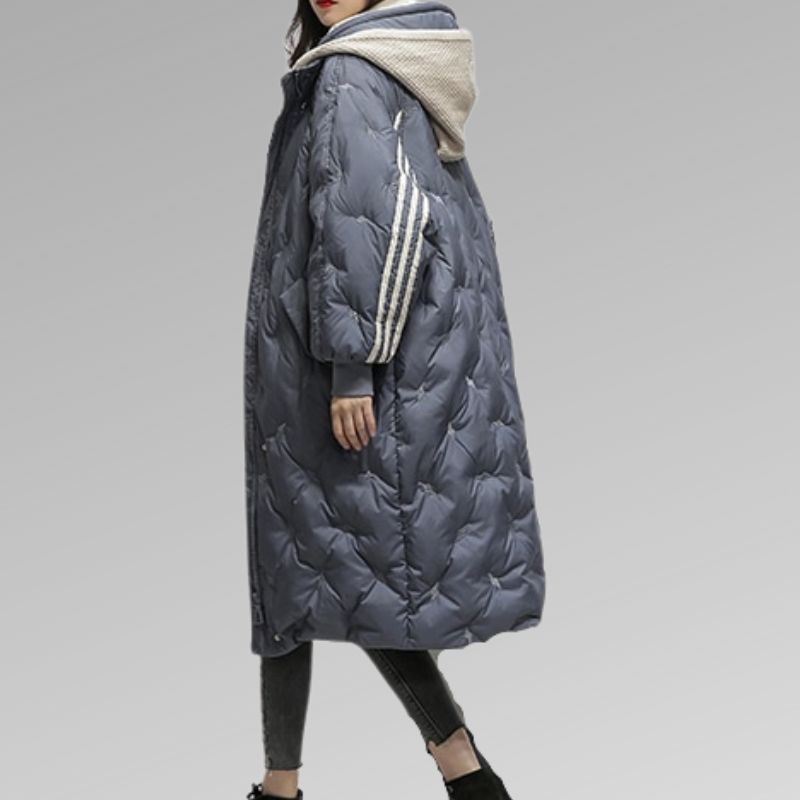 Michelle, doudoune longue bleu marine pour femme vue de profil, manteau d’hiver chaud avec capuche et bandes contrastantes sur les manches, style élégant et confortable.
