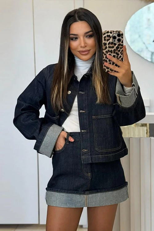 Ensemble femme moderne avec une veste en jean courte et une jupe assortie. La veste à boutons métalliques et les détails en denim clair sur les manches et la jupe apportent une touche tendance à cette tenue. Parfait pour un look chic et décontracté, ce style urbain offre confort et élégance, idéal pour une sortie quotidienne ou un événement casual.