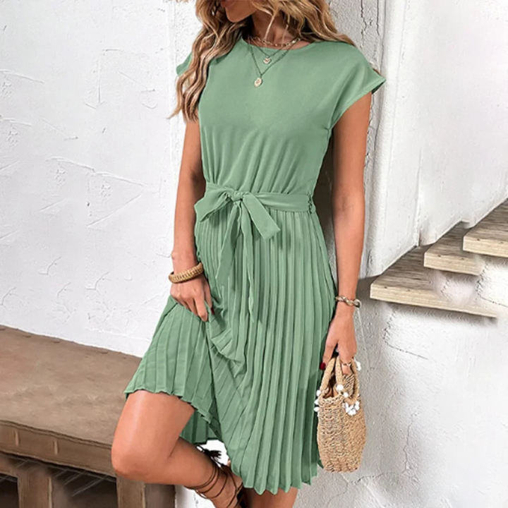 Robe élégante et tendance pour femme, en vert, avec une taille cintrée et un nœud décoratif. Le bas plissé et fluide ajoute une touche de mouvement, parfaite pour les journées ensoleillées. Idéale pour un look décontracté et raffiné.