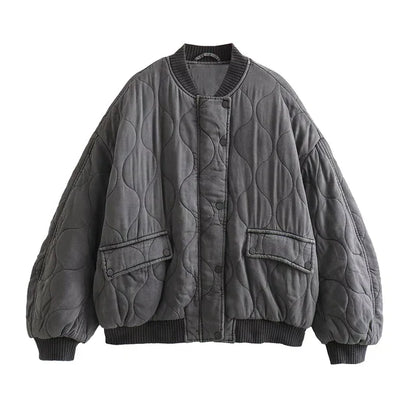 Blouson long gris "Nancy" pour femme avec un design matelassé, poches latérales et bord-côte au niveau des poignets et du bas, pour un look décontracté et tendance.