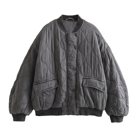 Blouson long gris "Nancy" pour femme avec un design matelassé, poches latérales et bord-côte au niveau des poignets et du bas, pour un look décontracté et tendance.