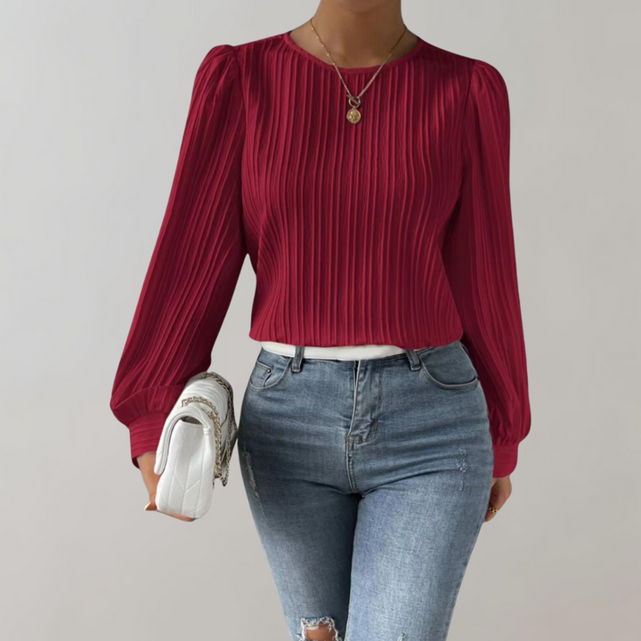 Haut à manches longues Nina pour femme, avec un design tendance et raffiné. Ce top à plis fins et coupe moderne se porte parfaitement avec un jean pour un look à la fois chic et décontracté. Idéal pour ajouter une touche élégante à votre garde-robe quotidienne.