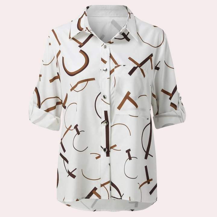 Chemise femme Nivelle blanche à manches retroussées avec motif de lettres graphiques marron. Modèle boutonné avec col classique et poche poitrine, parfait pour un look tendance, moderne et décontracté.