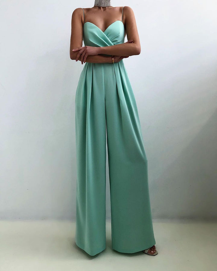 Combinaison longue vert menthe à fines bretelles, décolleté cœur croisé et taille marquée, avec pantalon large fluide, portée par un mannequin sur fond clair.