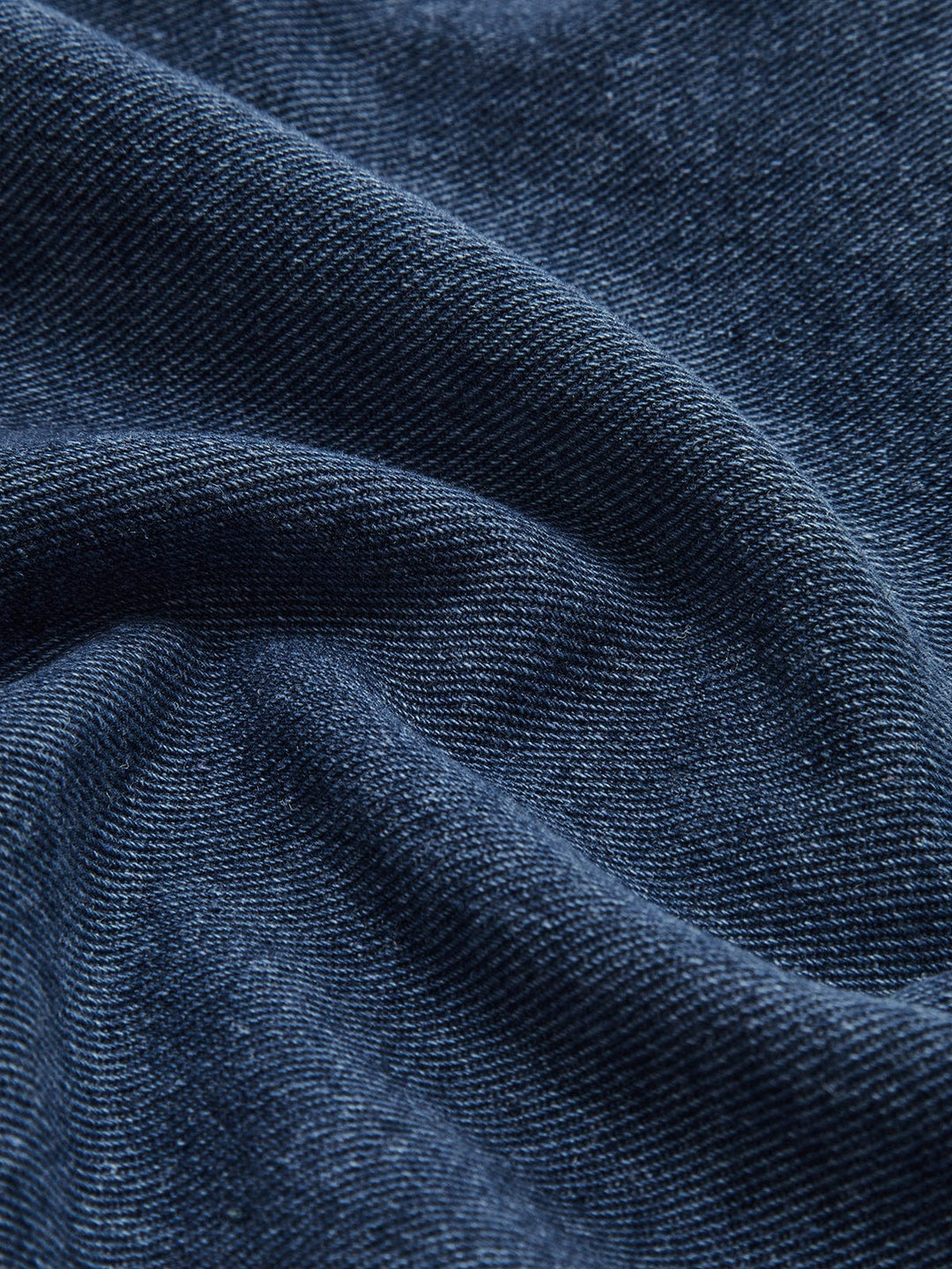 Détail du tissu en denim bleu de la veste en jean 'Nyselle' pour femme. Ce zoom met en évidence la texture douce et la finition de qualité du jean, offrant à la veste une allure moderne et confortable, idéale pour un style décontracté et élégant.