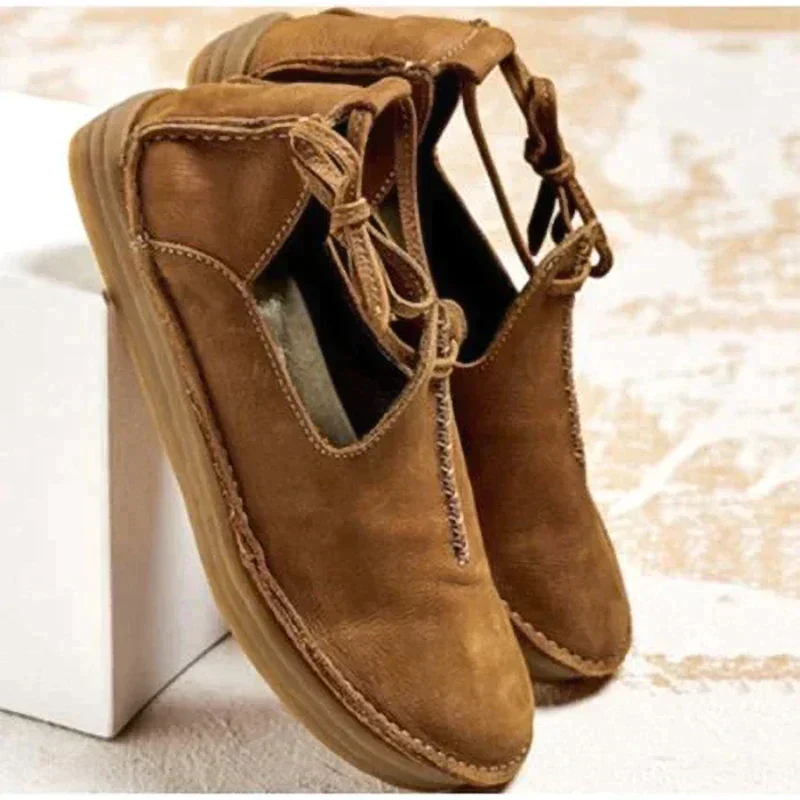 Chaussures d’automne pour femme en cuir marron camel, au style moderne et naturel, avec coutures artisanales apparentes, lien décoratif sur le côté, ouverture souple et semelle plate confortable, présentées sur un fond clair.