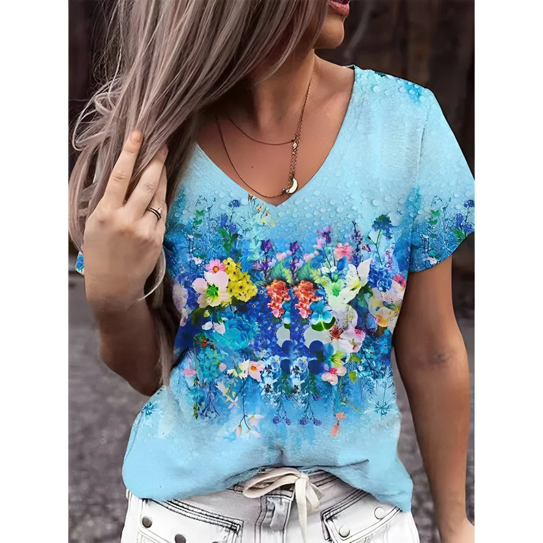 T-shirt bleu ciel à col V, avec imprimé floral multicolore au centre, porté par un mannequin.