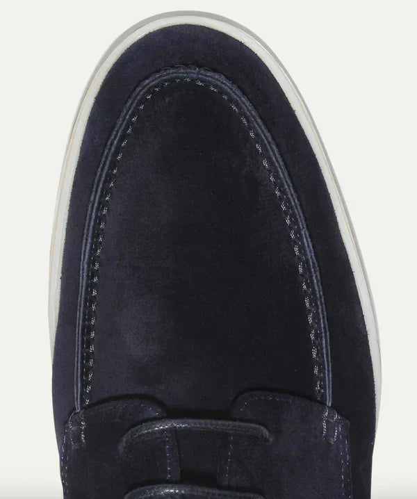 Gros plan sur l’avant des mocassins à lacets Paulin pour homme en suédine bleu marine, mettant en valeur les coutures raffinées, la texture haut de gamme et la semelle claire contrastante.