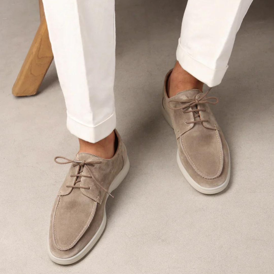 Homme portant les mocassins à lacets Paulin en suédine beige clair avec semelle blanche contrastante, associés à un pantalon blanc pour un look élégant, moderne et décontracté.
