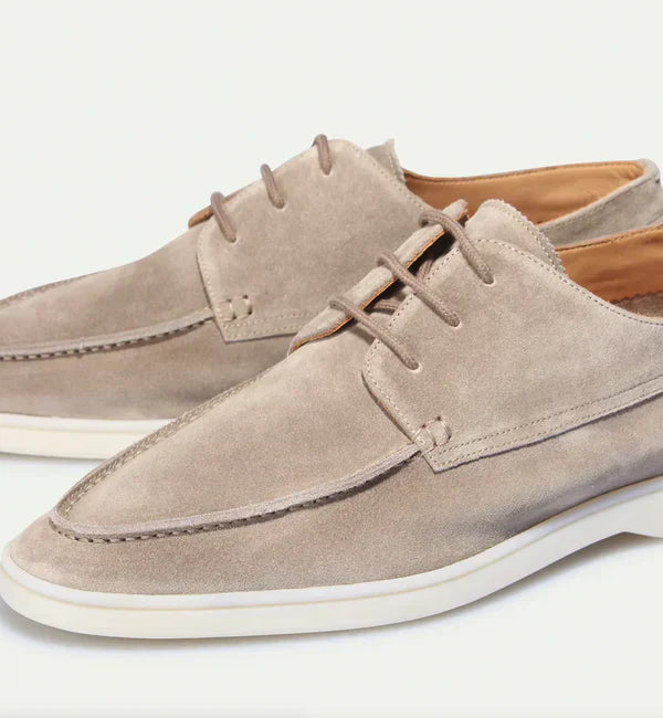 Gros plan sur les mocassins à lacets Paulin pour homme en suédine beige clair, mettant en valeur la finition haut de gamme, les coutures élégantes et la semelle claire au style moderne.
