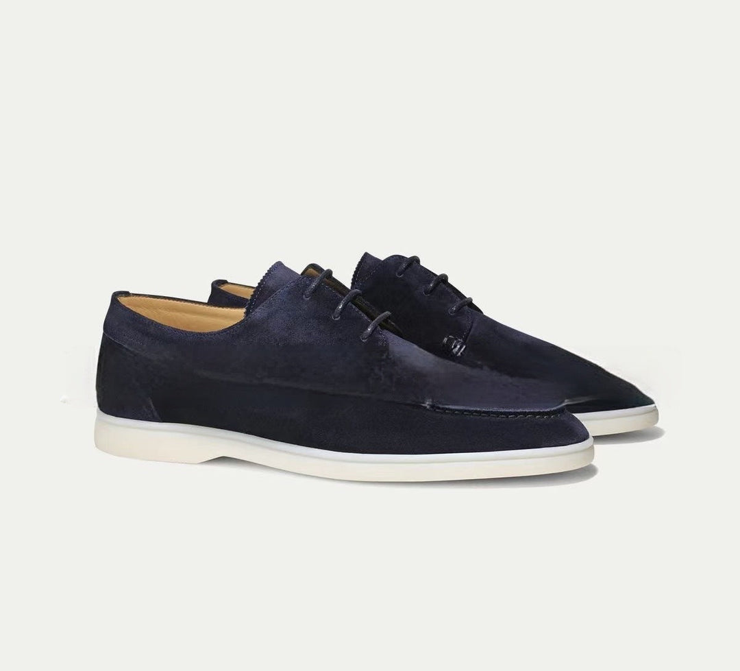 Paire de mocassins à lacets Paulin pour homme en suédine bleu marine, avec silhouette élégante et semelle claire contrastante, parfaite pour un look moderne et raffiné.