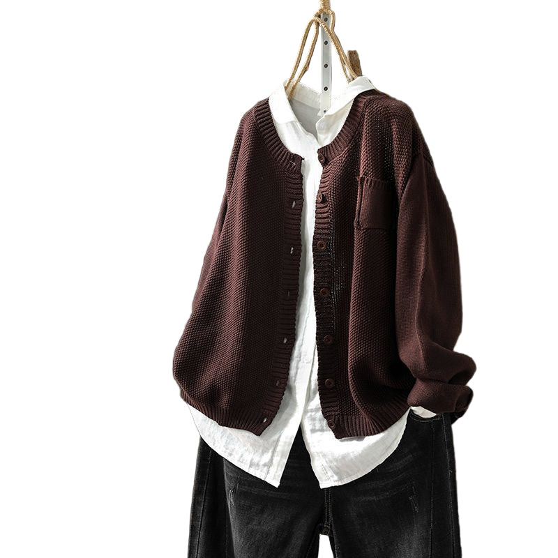 Gilet oversize couleur café pour femme, présenté sur un cintre porté sur une chemise blanche ample. Ce modèle en maille texturée, à la coupe décontractée et boutonné sur le devant, offre un style moderne et décontracté.