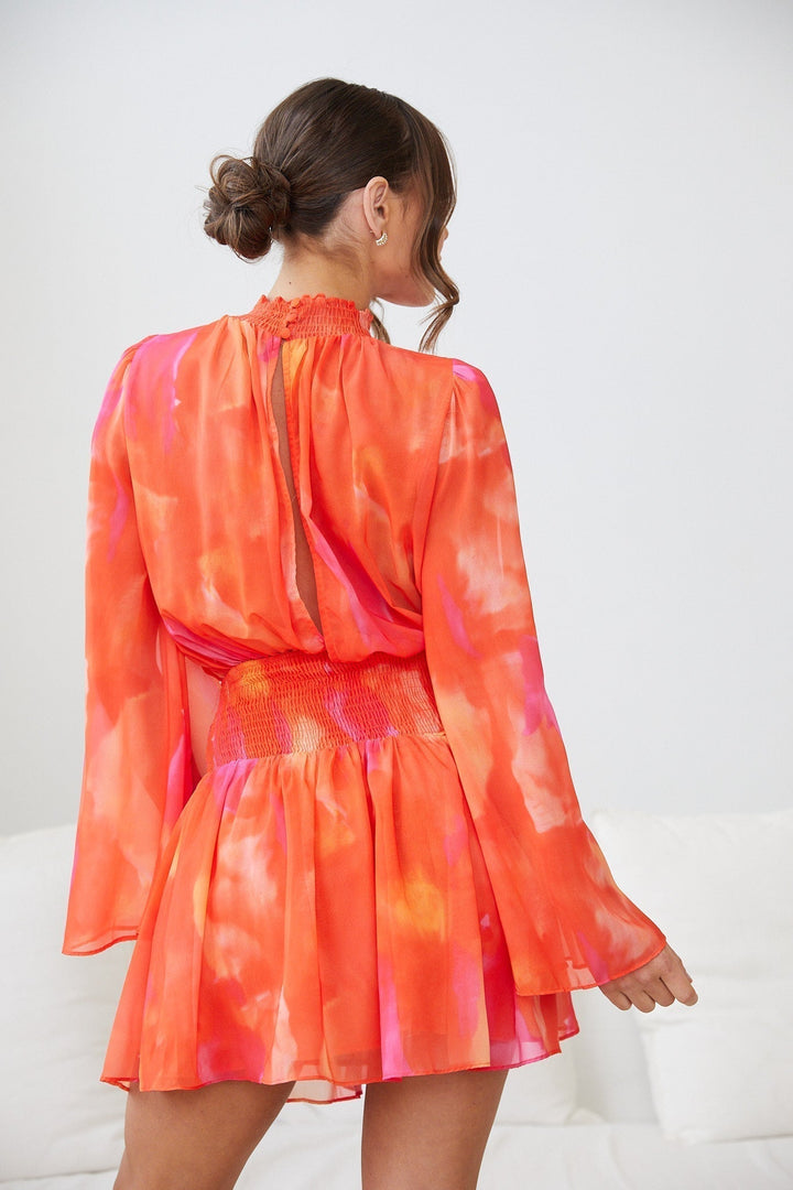 Robe mini d'été à manches longues pour femme, de style moderne, avec un décolleté délicat et un design coloré en dégradé de rose et orange. Le tissu fluide et léger crée une silhouette féminine et élégante, idéale pour les journées estivales.
