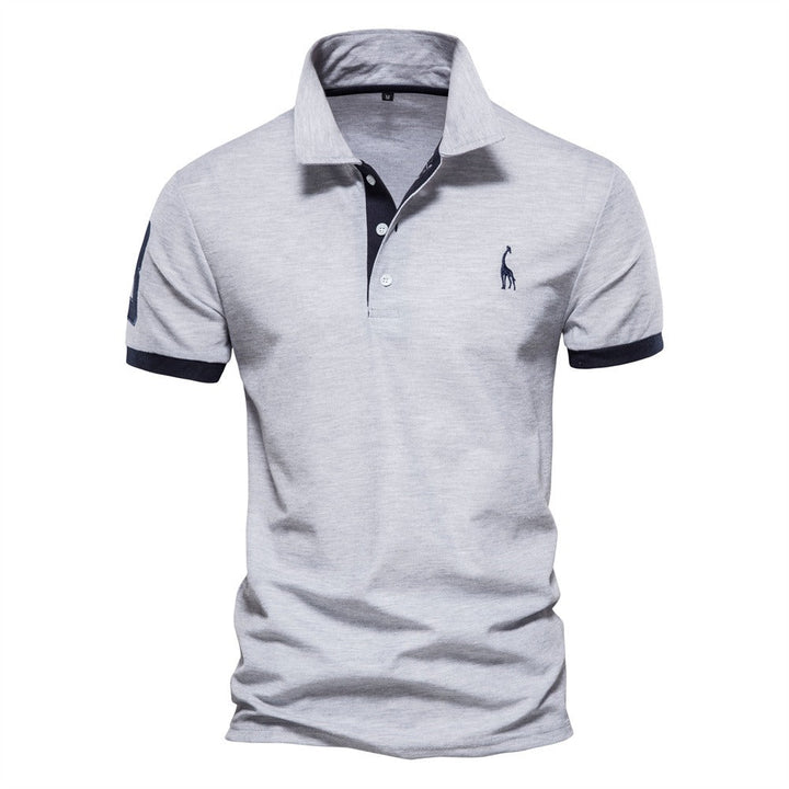 Polo homme Philippe tendance en gris clair, avec col classique à boutons et finitions contrastées sur les manches et le col, offrant un style moderne et élégant au quotidien.