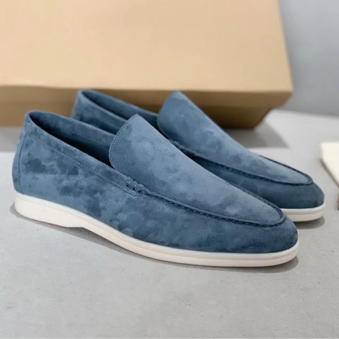 Mocassins en daim bleu élégant avec une finition soignée et une semelle blanche, parfaits pour un look moderne et raffiné.