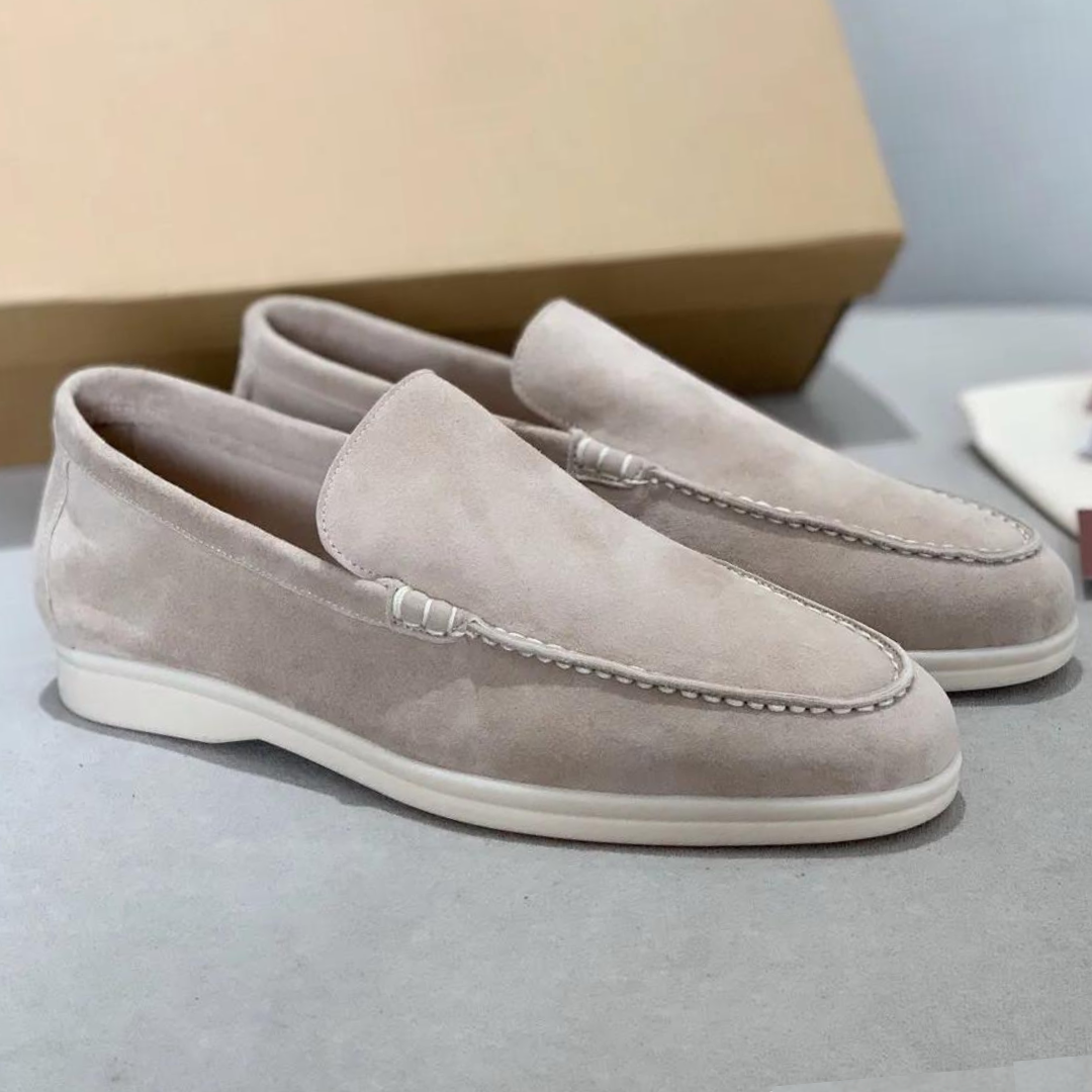 Mocassins en daim beige clair avec une finition élégante et une semelle blanche, alliant confort et raffinement pour un style moderne et sophistiqué.