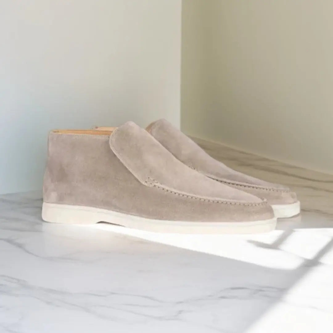 Mocassins en daim beige clair avec une semelle blanche, offrant un style épuré et moderne, parfaits pour un look sophistiqué et contemporain.