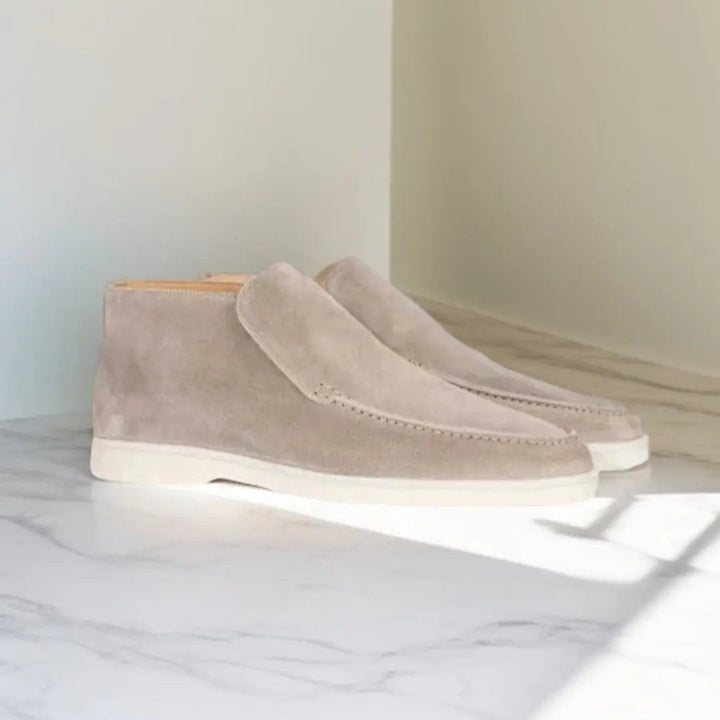 Mocassins en daim beige clair avec une semelle blanche, offrant un style épuré et moderne, parfaits pour un look sophistiqué et contemporain.