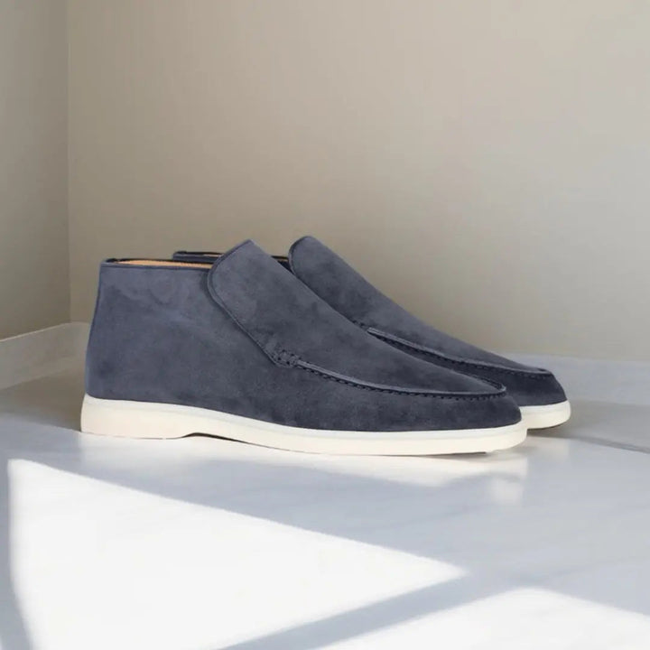 Mocassins en daim bleu foncé avec une semelle blanche, offrant un style moderne et élégant, parfaits pour une allure sophistiquée et contemporaine.
