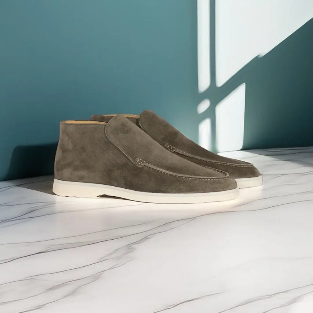 Mocassins en daim gris avec une semelle blanche, offrant un style contemporain et élégant, parfaits pour un look moderne et raffiné.