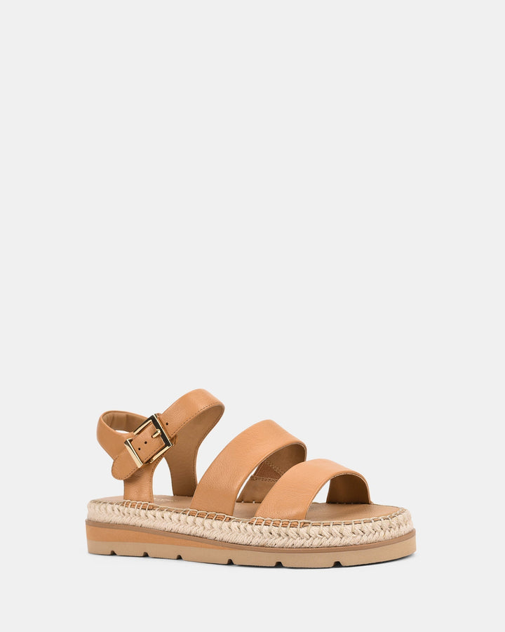 Sandales pour femmes de couleur caramel avec deux brides larges à l’avant et une sangle ajustable à la cheville avec boucle. Semelle plateforme ornée d’un contour tressé style espadrille, alliant confort et look tendance.