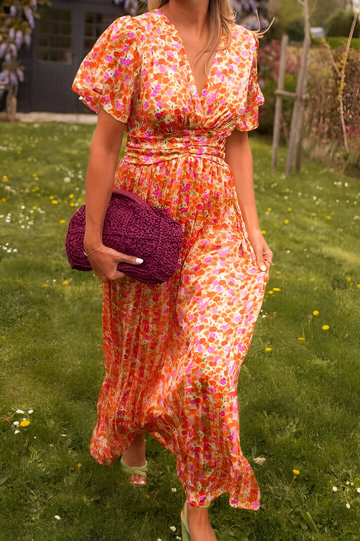 Robe longue à col en V pour femme, modèle tendance. Cette robe fluide et colorée, aux motifs floraux dans des teintes vibrantes de rose, orange et jaune, est parfaite pour les journées estivales. Portez-la avec des accessoires modernes comme un sac en crochet violet et des sandales élégantes. Un choix incontournable pour un look chic et décontracté.