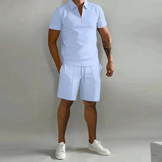 Homme portant l’ensemble Rupert bleu clair avec polo zippé à manches courtes et short assorti, parfait pour un look d’été moderne et décontracté.