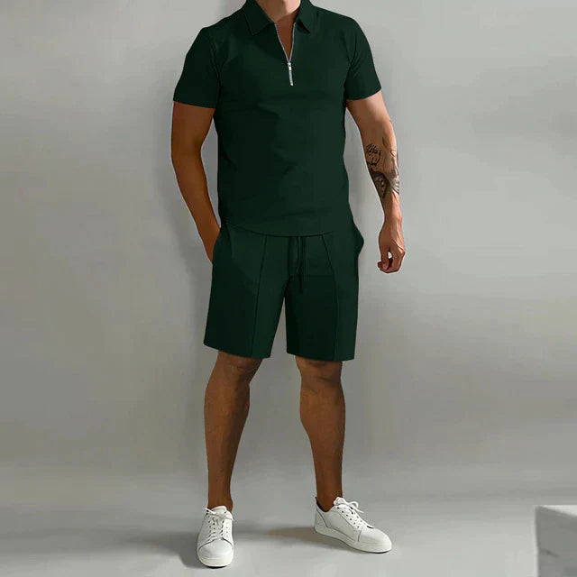 Homme portant l’ensemble Rupert vert foncé avec polo zippé à manches courtes et short assorti, idéal pour un look d’été moderne et décontracté.