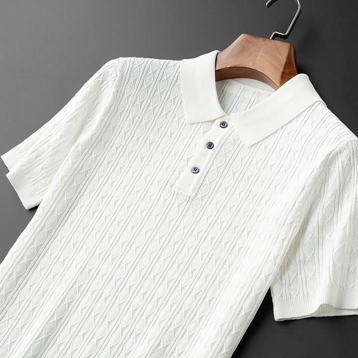 Polo premium pour homme Sabin en blanc élégant, présenté sur cintre, avec col classique, manches courtes et texture en maille raffinée, offrant un style moderne et tendance.