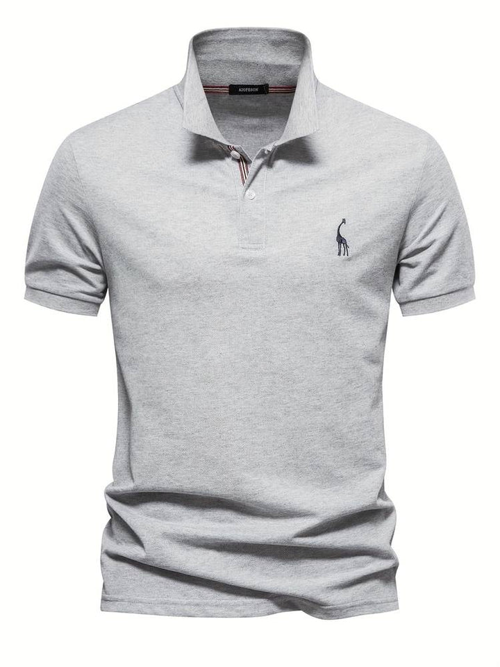 Polo moderne pour homme Sami, gris clair à manches courtes, avec col structuré, patte de boutonnage et logo brodé discret sur la poitrine, pour un style élégant et contemporain.