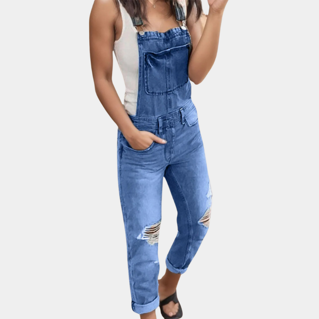 Salopette moderne pour homme en denim bleu, avec un design décontracté et des détails déchirés. Confortable et tendance, idéale pour un look casual et stylé.