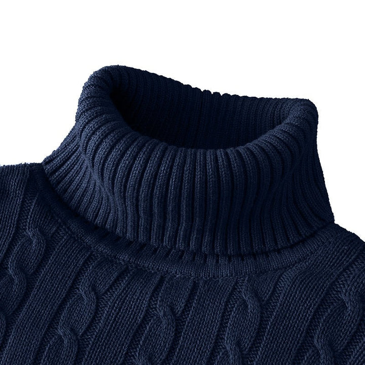 Pull bleu marine en maille torsadée avec col roulé épais et côtelé, idéal pour un style élégant et confortable durant l’hiver.