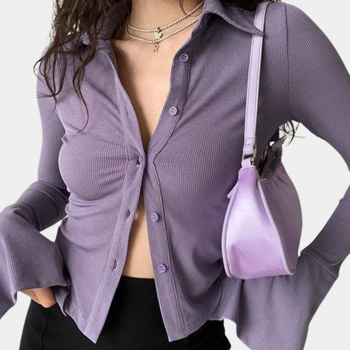 Chemise femme Solaria violette à manches longues avec coupe ajustée et tissu côtelé. Modèle boutonné avec col classique et manches légèrement évasées, idéal pour un look moderne, féminin et tendance.