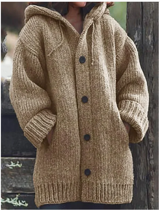 Une femme porte un long cardigan kaki à manches bouffantes, poches latérales et boutons foncés, pour un look à la fois chaud et décontracté.
