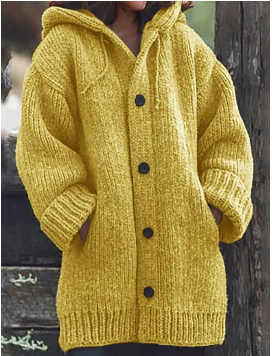Femme portant un long cardigan épais en maille jaune moutarde, à manches larges, poches latérales et boutons foncés, offrant un style hivernal chaud et confortable.