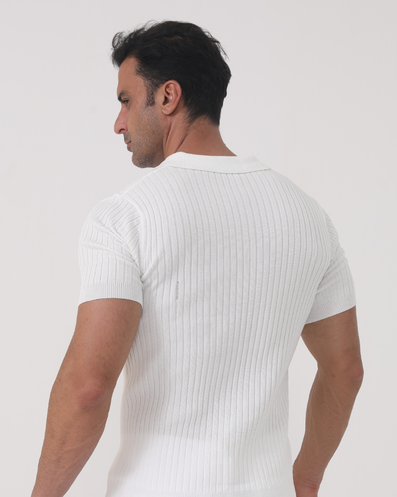 Vue arrière d’un homme portant le polo Sully en maille côtelée blanc, à manches courtes avec col en V, coupe ajustée mettant en valeur la silhouette pour un style moderne et tendance.