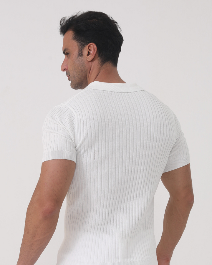 Vue arrière d’un homme portant le polo Sully en maille côtelée blanc, à manches courtes avec col en V, coupe ajustée mettant en valeur la silhouette pour un style moderne et tendance.