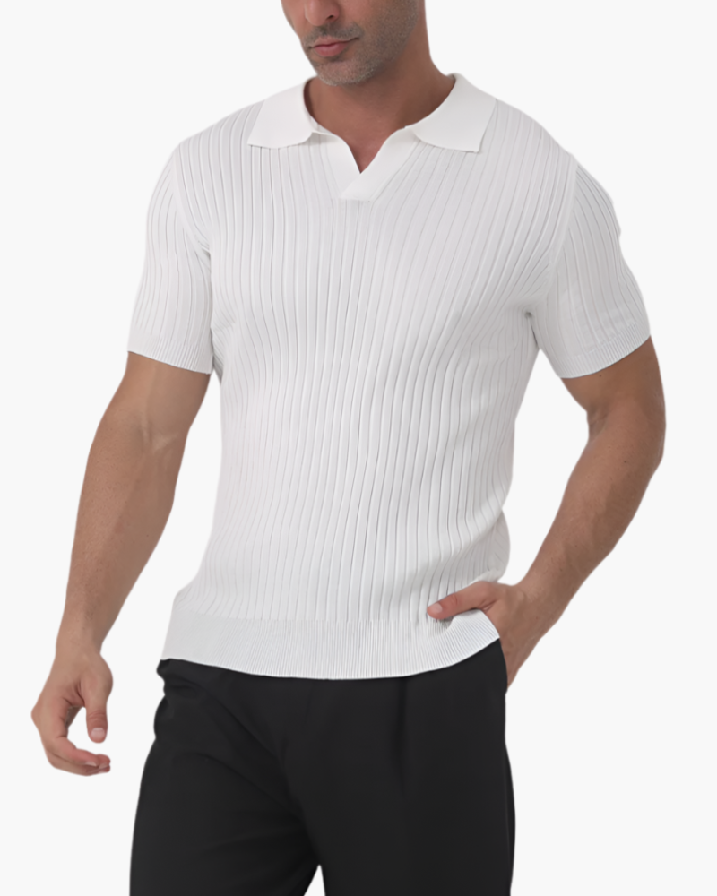 Homme portant le polo Sully en maille côtelée blanc, à manches courtes avec col en V, offrant une coupe ajustée, une texture élégante et un style moderne et tendance, associé à un pantalon sombre.