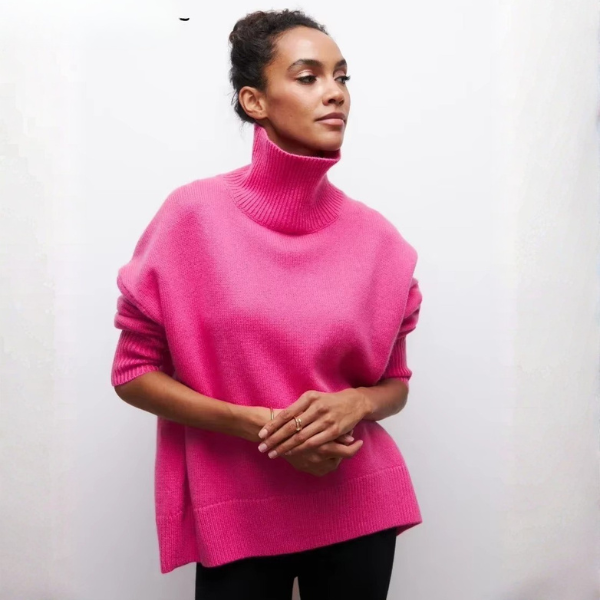Pull oversize à col roulé pour femme, en rose vif, avec une coupe ample et des manches courtes. Le col roulé est large et côtelé, tandis que le bas du pull présente également une finition côtelée. Le vêtement offre un look moderne et audacieux, parfait pour un style décontracté et élégant.