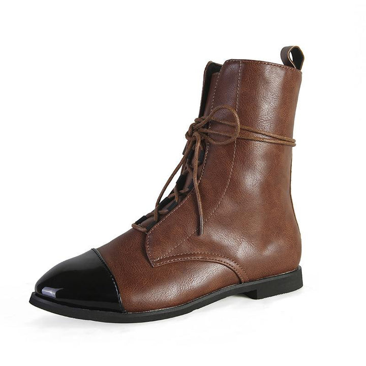 Bottine cheville pour femme en cuir marron avec lacets, bout noir verni et semelle plate, présentée sur fond blanc, au style tendance et élégant pour l’automne et l’hiver.