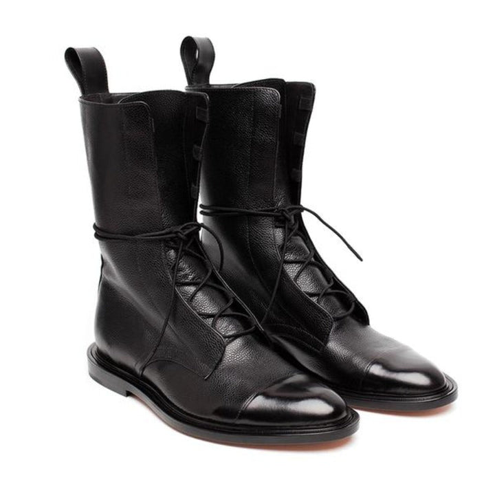 Paire de bottines cheville pour femme en cuir noir avec lacets, tige mi-haute et finition brillante sur l’avant, présentées sur fond blanc, au style tendance et élégant.