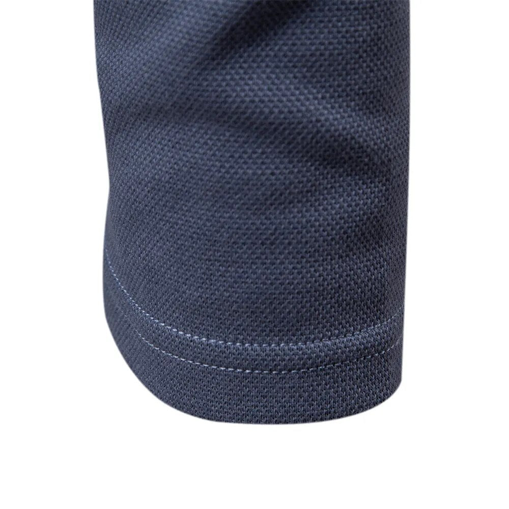 Détail du bas de manche du polo homme bleu, avec une finition soignée et une couture discrète, soulignant la coupe moderne et élégante.