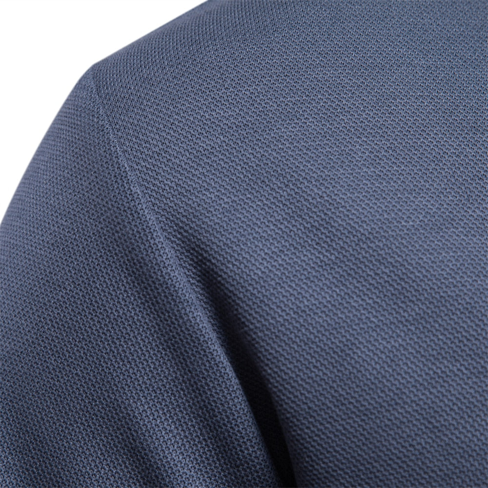 Détail du tissu du polo homme bleu, avec une texture en maille fine, offrant une finition élégante et moderne.