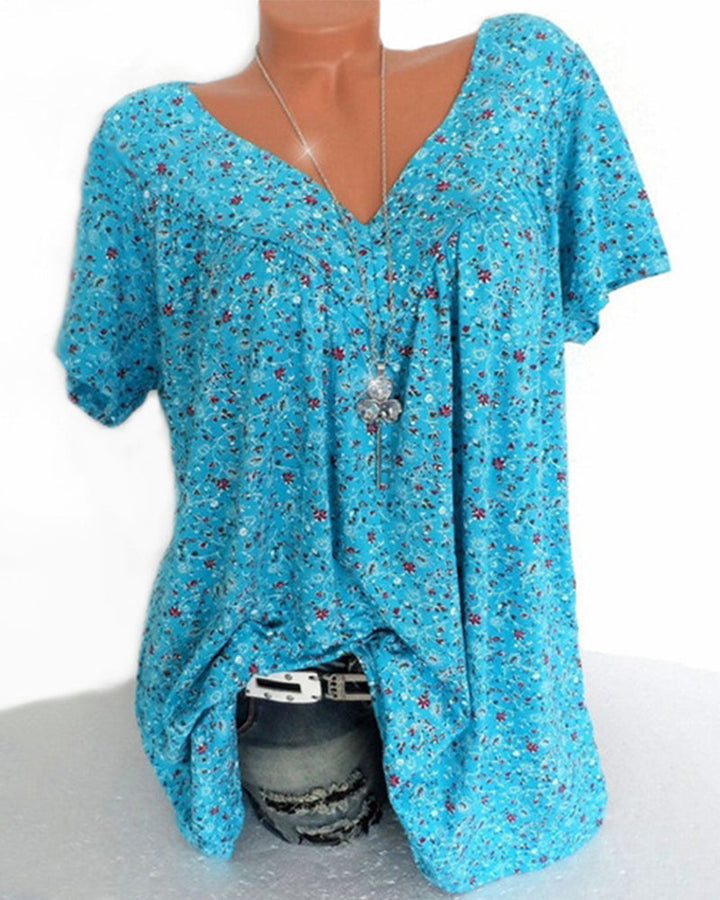 Blouse Verity pour femme à manches courtes, coupe ample et fluide avec col V, imprimé fleuri moderne bleu turquoise, portée avec un jean  style léger, décontracté et tendance.
