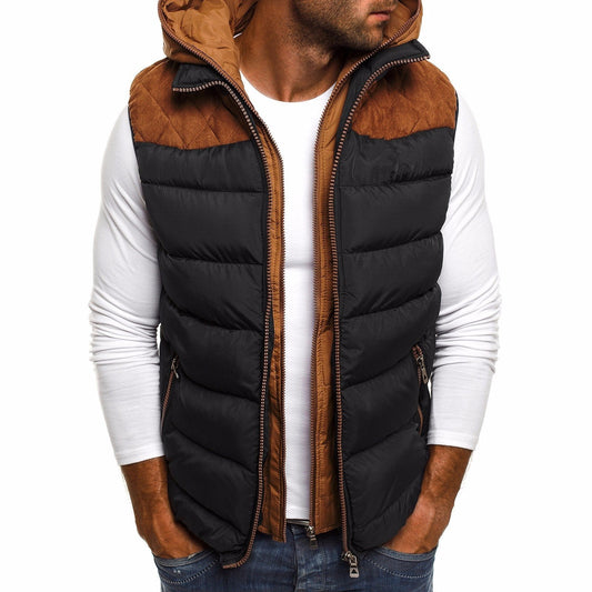 Un homme portant un gilet matelassé noir et marron avec une capuche, doté de panneaux matelassés sur les épaules et de poches latérales, associé à une chemise à manches longues blanche, conçu pour offrir de la chaleur en hiver et pour les activités de plein air.