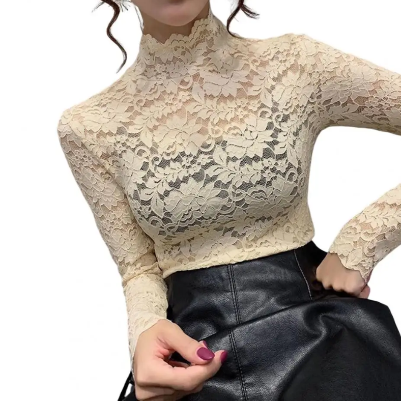 Haut en dentelle pour femme beige clair, à manches longues avec col montant, coupe ajustée et motifs floraux élégants, style chic et tendance associé à une jupe noire.