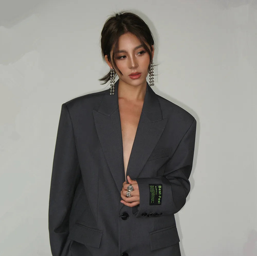 Femme portant le blazer Abella chic pour femme, veste oversize grise à épaules larges, style élégant et moderne, parfait pour un look tendance habillé ou professionnel.