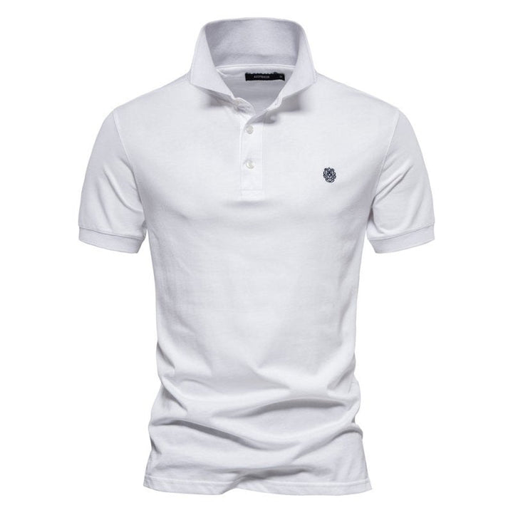 Polo homme blanc à coupe ajustée, style intemporel et élégant, avec col classique, patte de boutonnage et logo discret sur la poitrine.