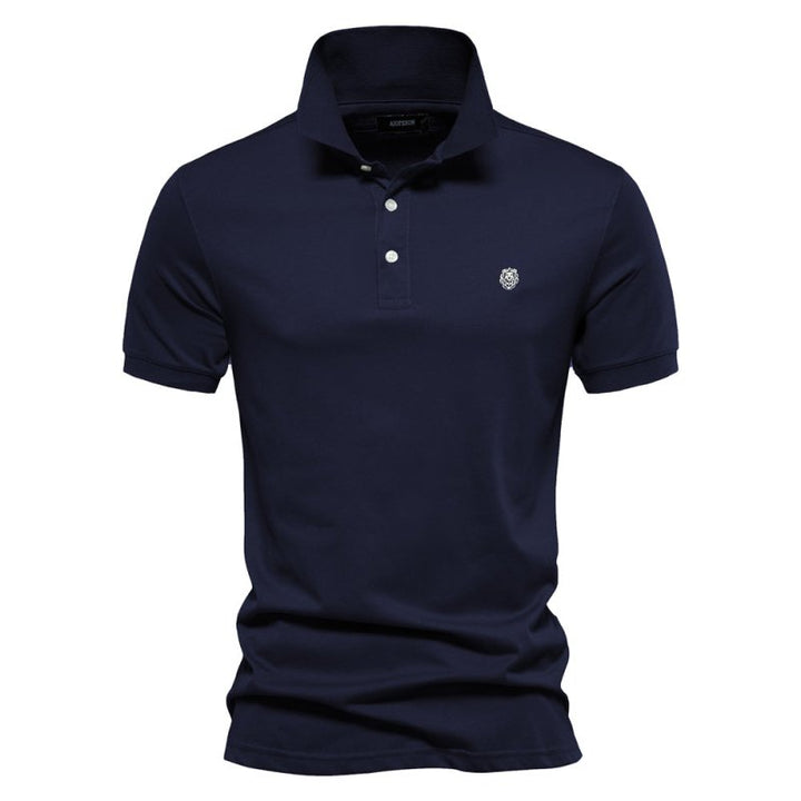 Polo homme bleu marine à coupe ajustée, design intemporel et élégant, avec col classique, patte de boutonnage et logo discret sur la poitrine.